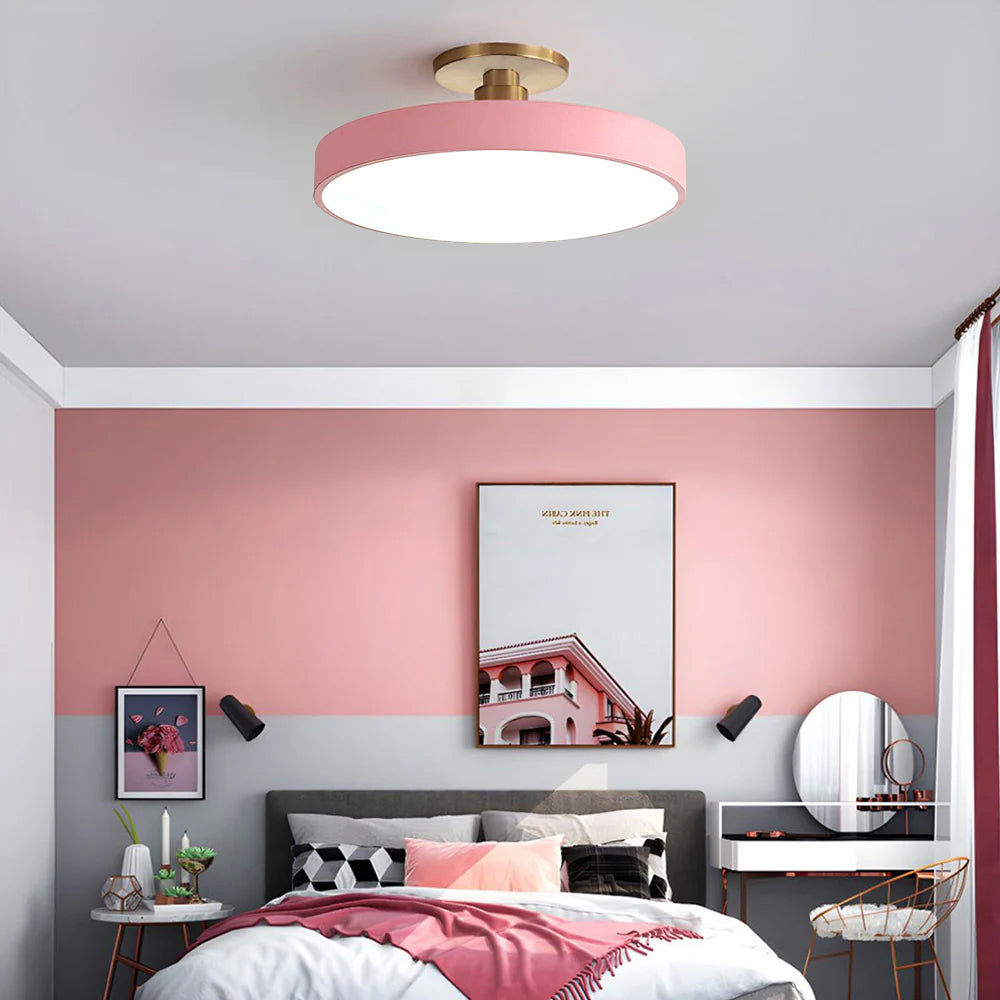 Pink round LED guoj ceiling fixture enhancing a beautifully styled pink and grey bedroom