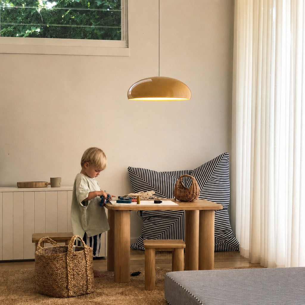 Orange Bauhaus dome huhs pendant light illuminating a child's wooden play table in a bright room