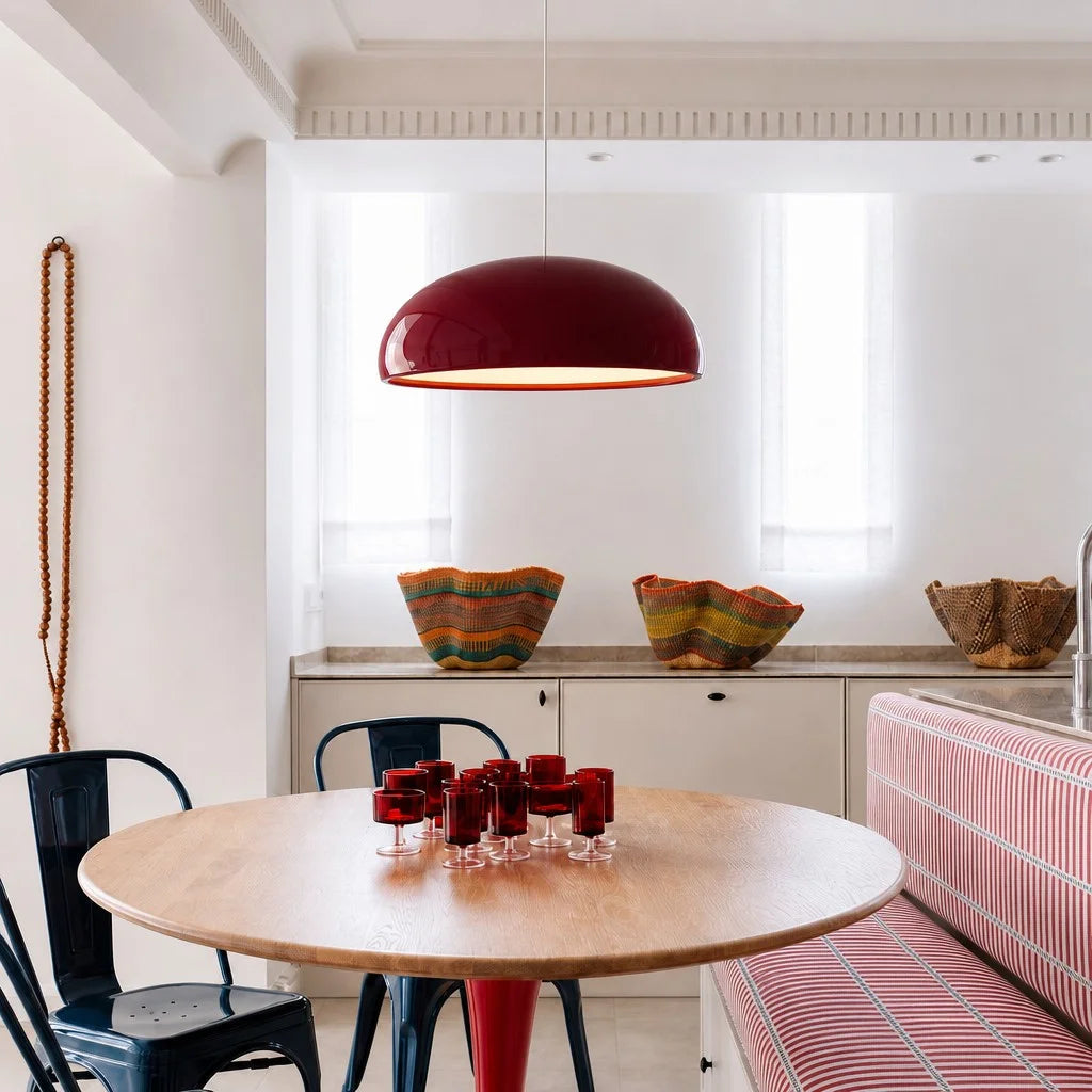 Red metal dome huhs ceiling lamp illuminating a bright, contemporary open-plan kitchen and dining space