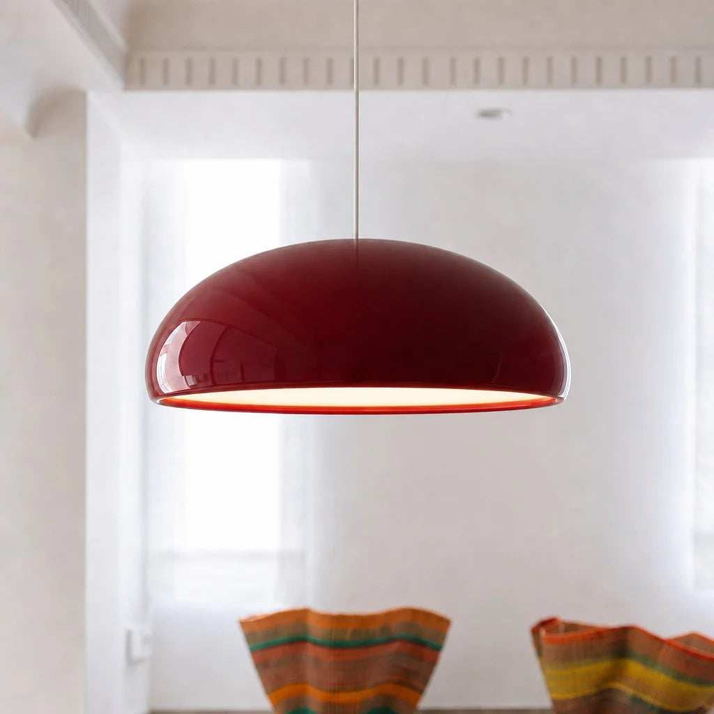 Red mid-century dome huhs pendant light suspended over a stylish dining table setup
