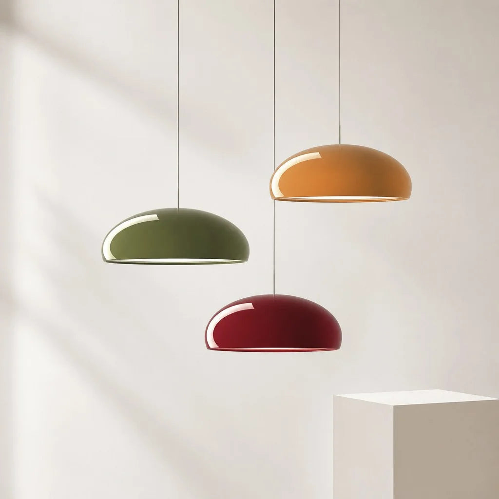Three multicoloured Bauhaus huhs pendants in green, orange, and red hanging at staggered heights