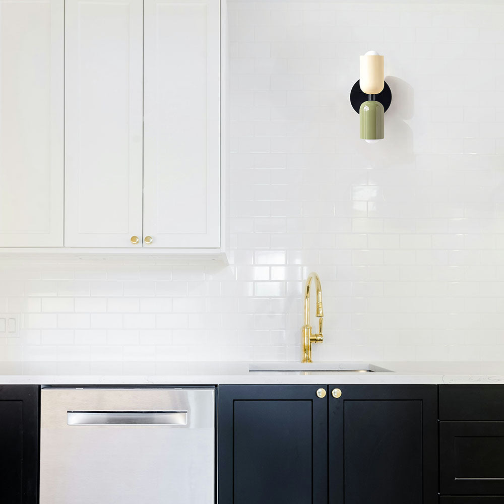 Colour-block glass hutre wall sconce adding a retro mid-century touch to a minimalist white kitchen
