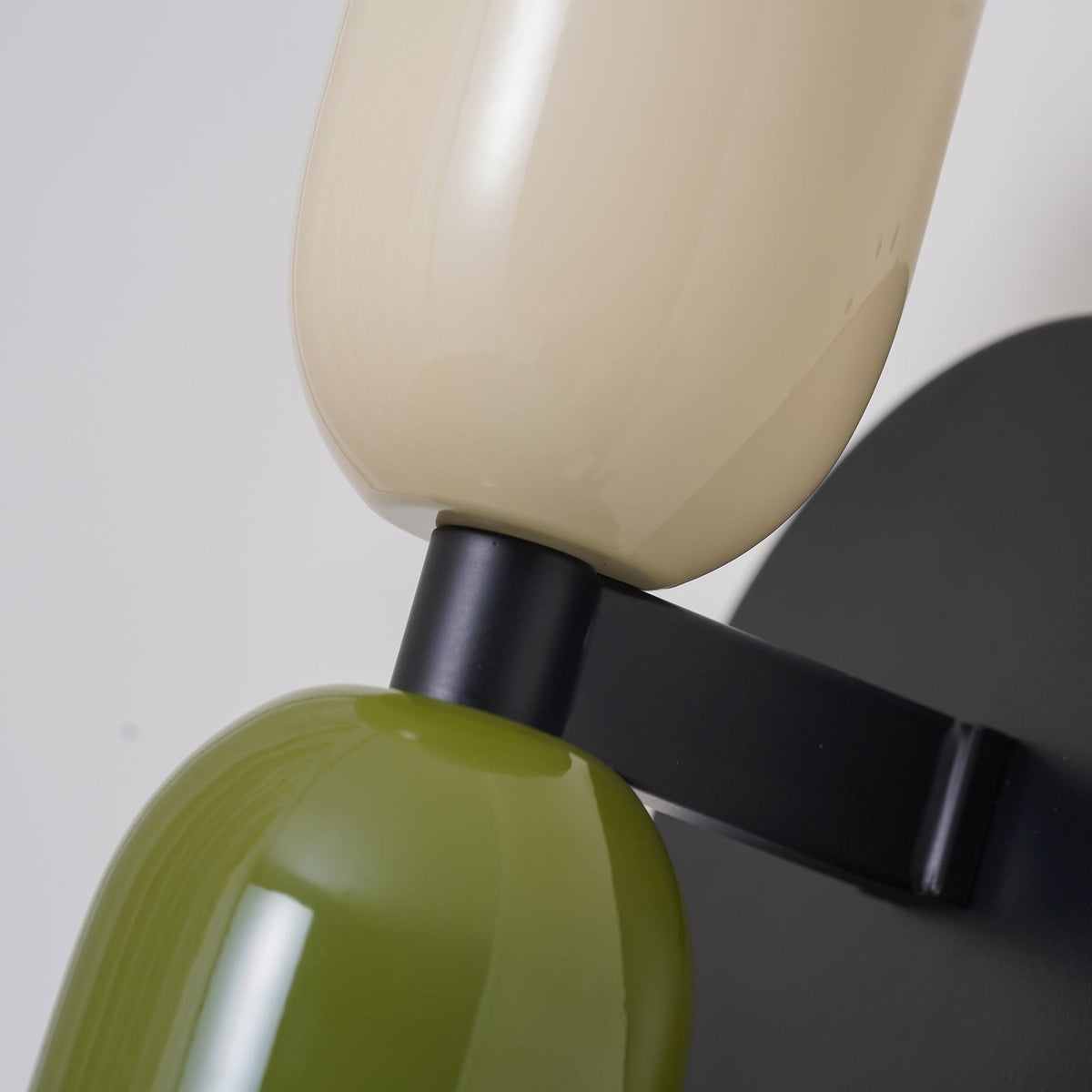 Close-up detail of the hutre metal hardware and premium tinted glass shades on the double-head sconce