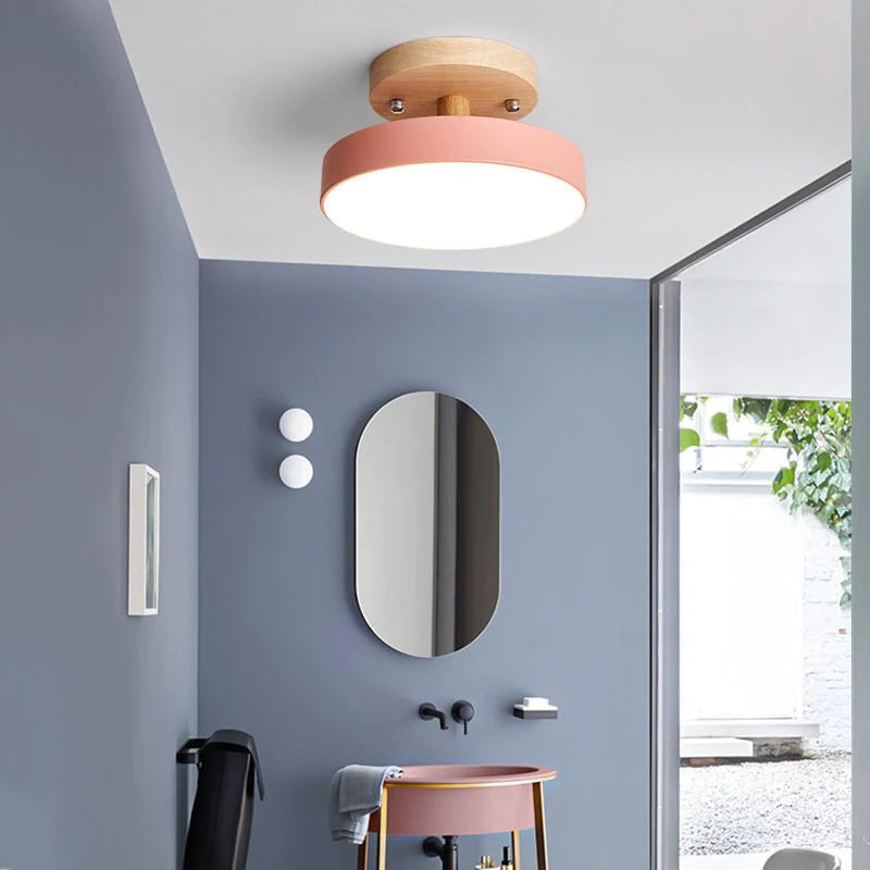 Pink modern semi flush mount huty ceiling light illuminating a contemporary bathroom vanity area