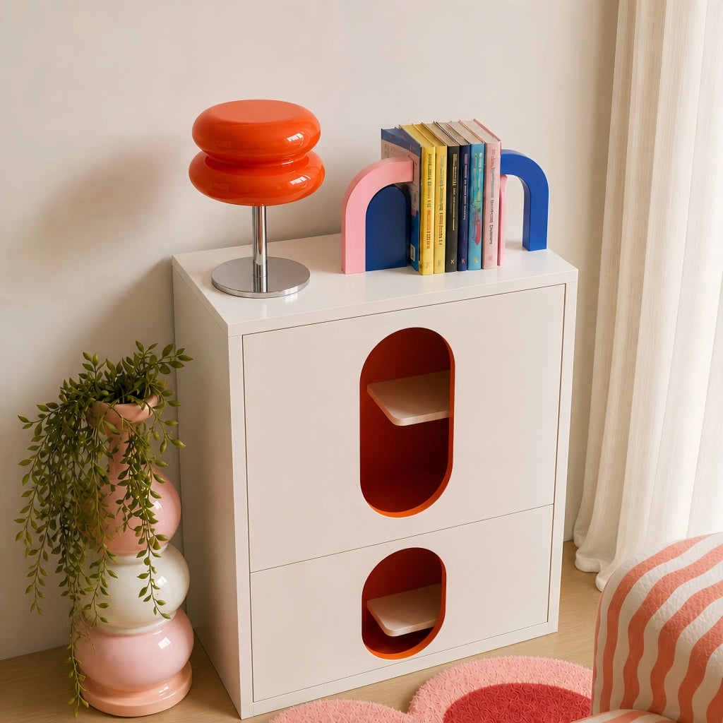 Vibrant orange macaron hutyl glass accent lamp adding a pop of colour to a modern white cabinet