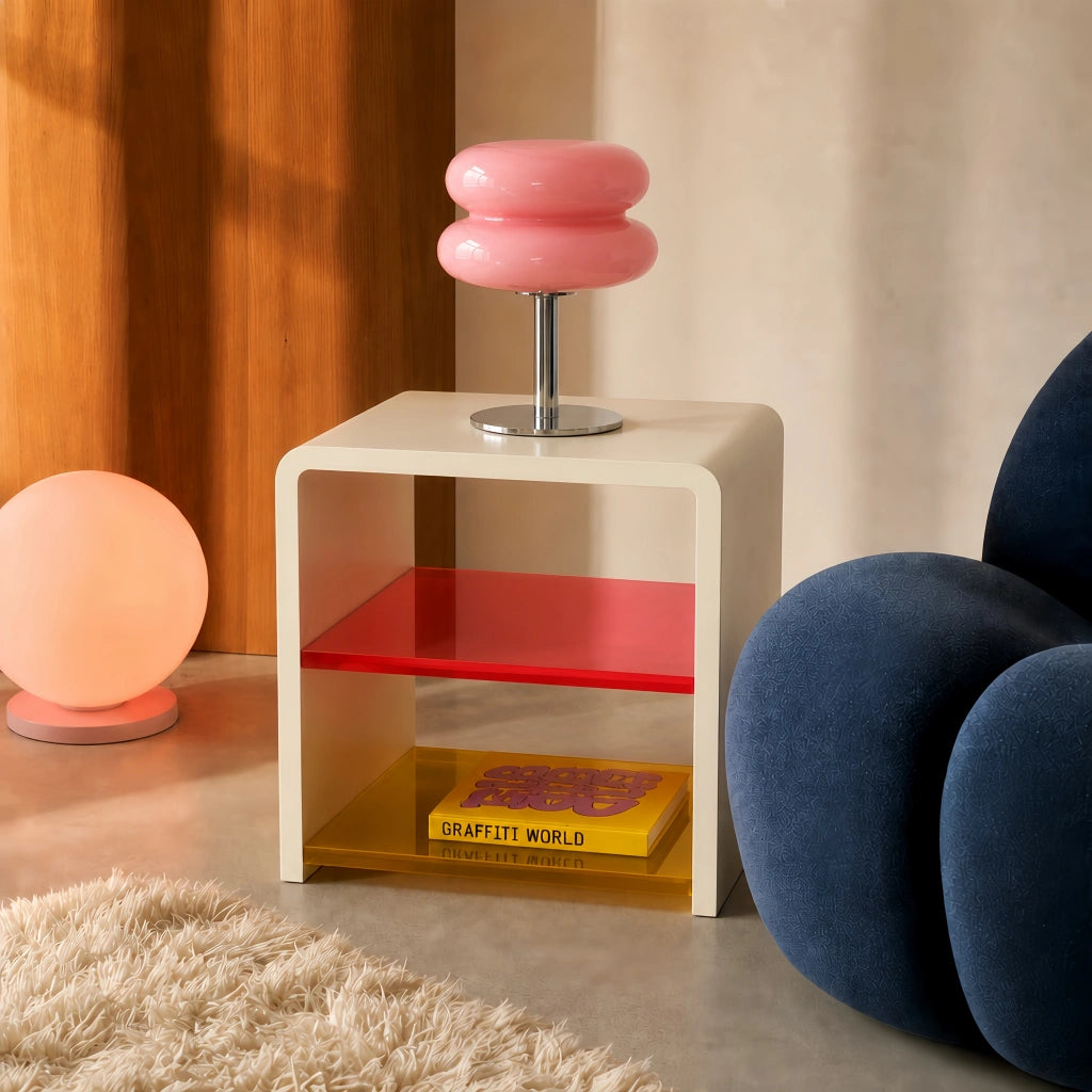 Pink Bauhaus hutyl glass side table light sitting on a retro acrylic stand next to a blue sofa