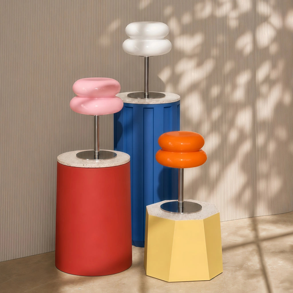 Pink and orange and white mid-century modern hutyl desk lamps styled on colourful geometric pedestals.