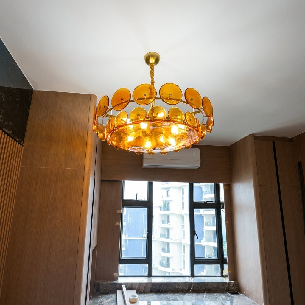 Joltly amber glass disc chandelier lit in a room with a window and wooden wall panelling