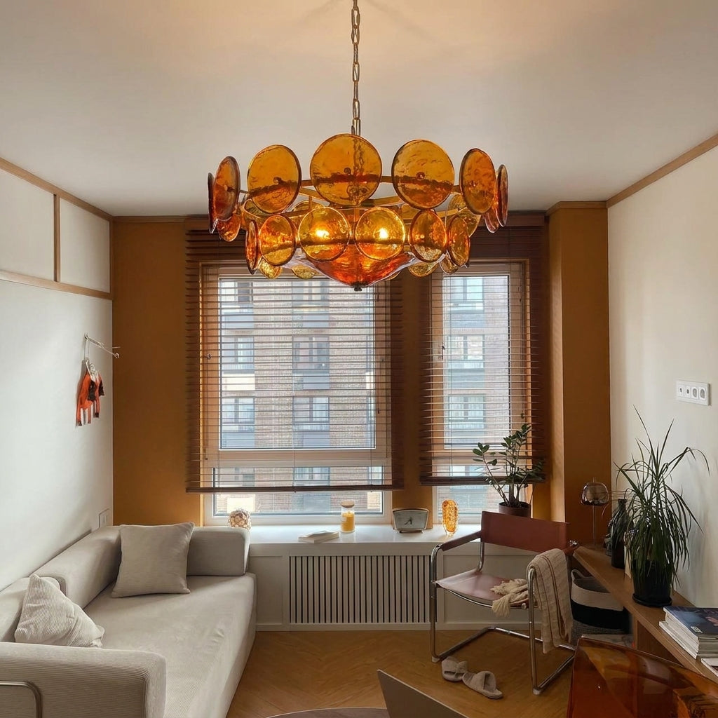 Joltly amber glass disc chandelier hanging in a living room in front of a window