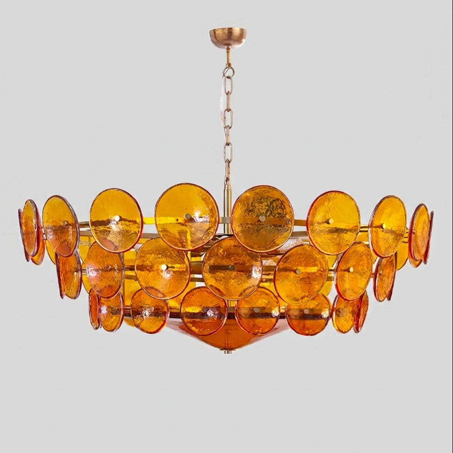 Joltly amber glass disc chandelier with gold-finish frame on a light grey background