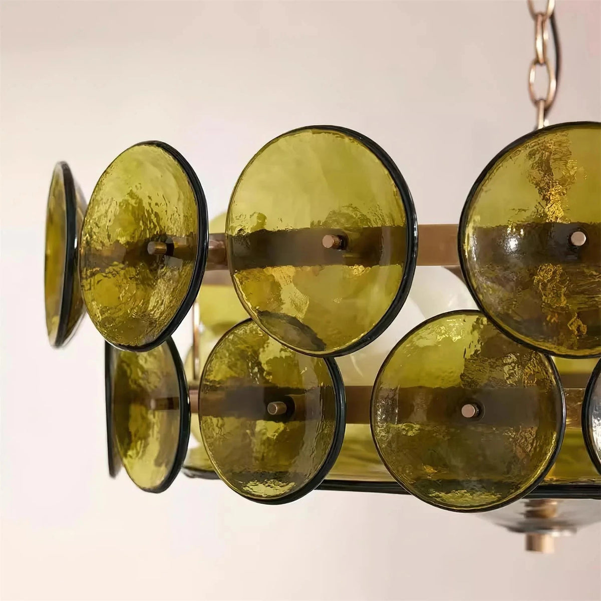 Close-up of the green glass discs and gold-finish frame of the Joltly chandelier