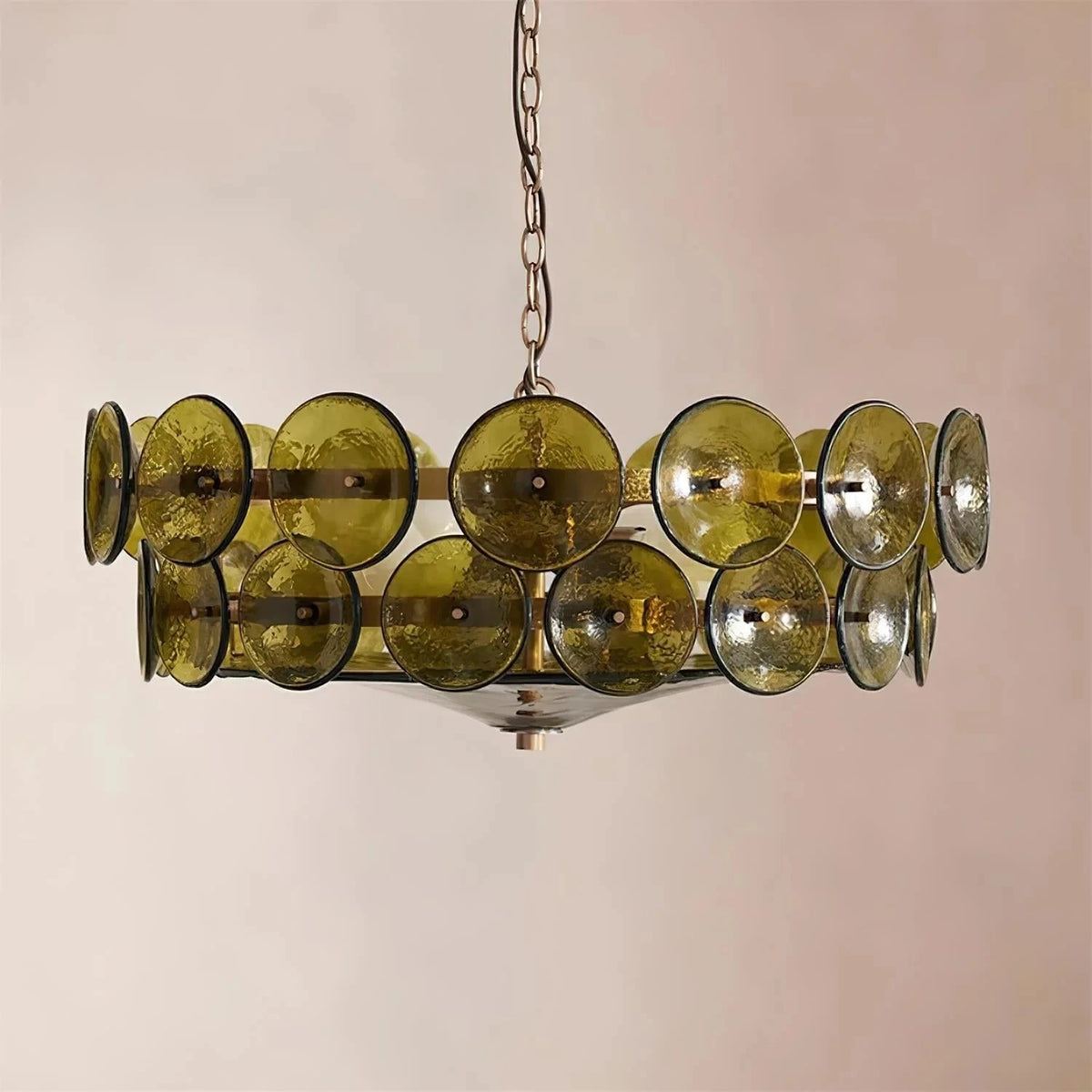 Joltly green glass disc chandelier hanging against a plain beige wall
