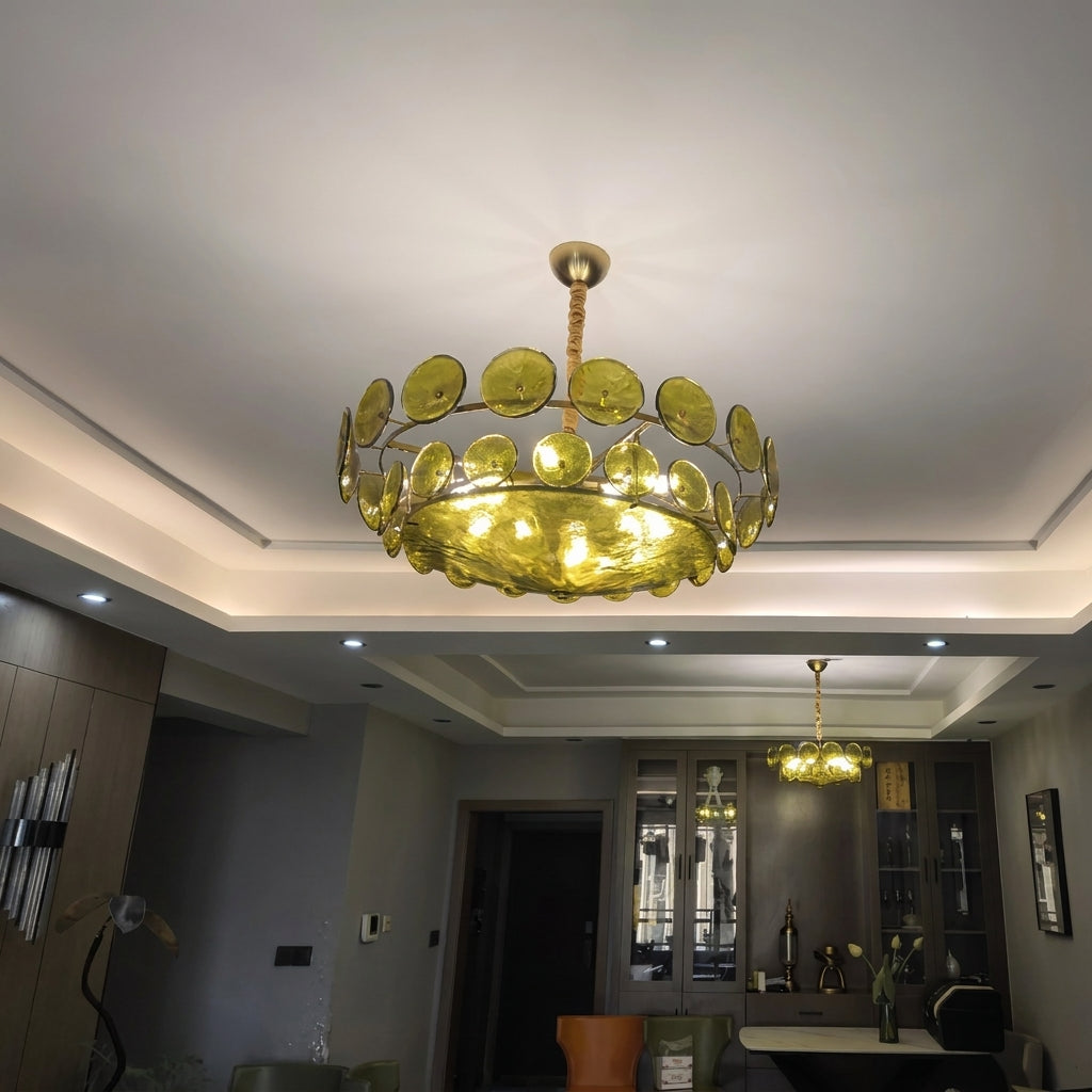 Joltly green glass disc chandelier lit in a lounge with a recessed ceiling