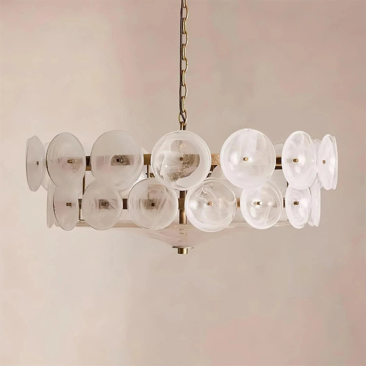 Joltly white frosted glass disc chandelier hanging against a plain beige wall