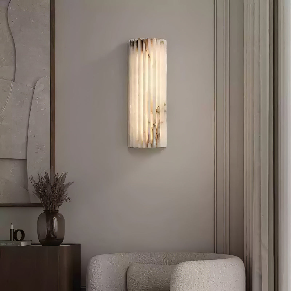 Illuminated alabaster jopna wall sconce adding a luxurious touch to a cosy living room corner