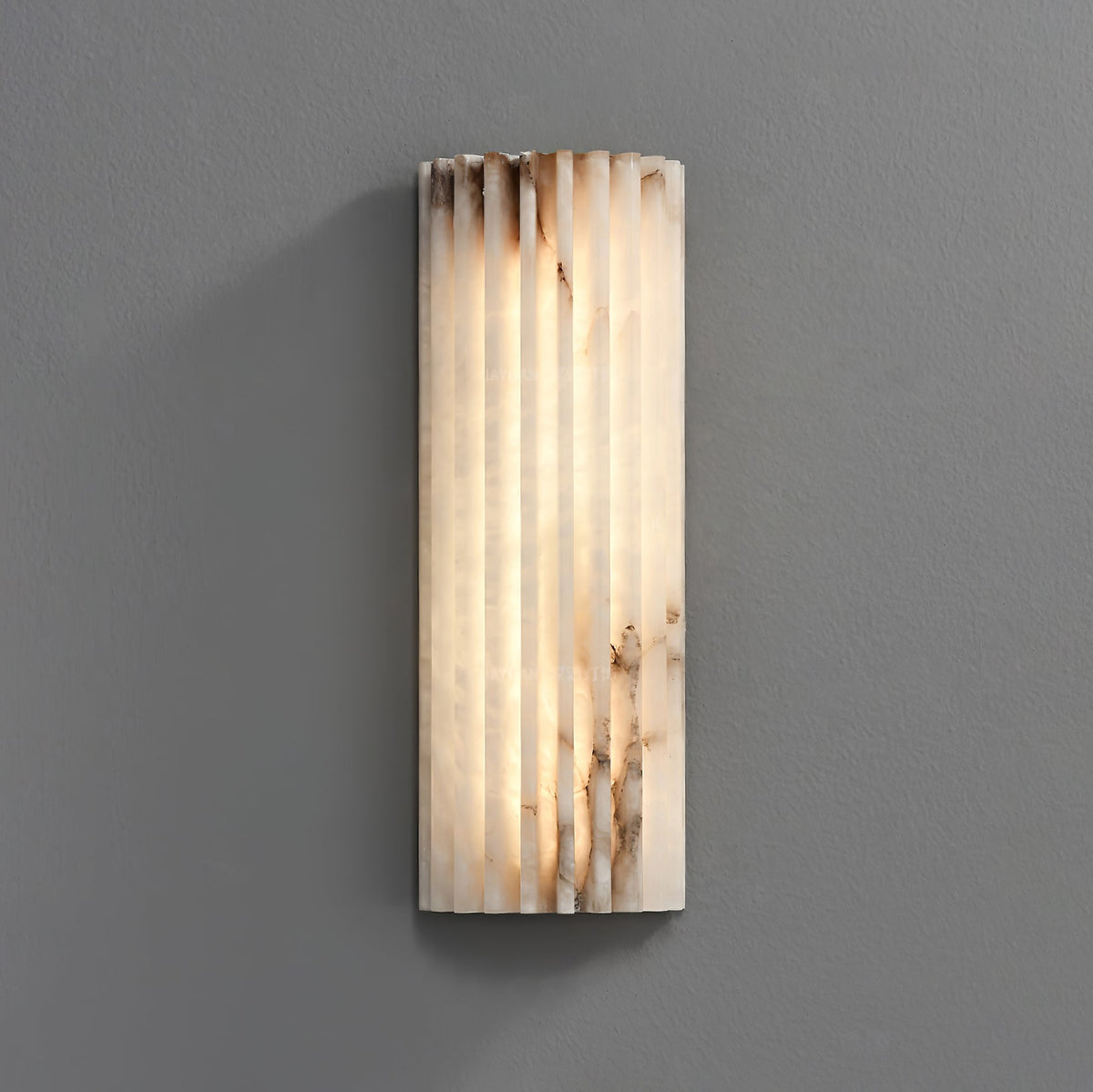 Modern jopna fluted alabaster LED wall sconce highlighting its natural ribbed texture and glowing marble veining