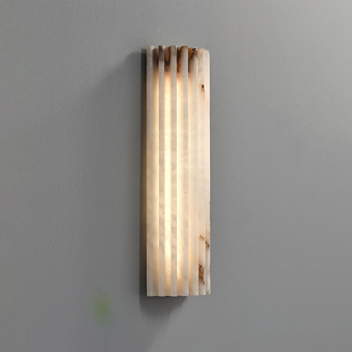 ribbed alabaster stone jopna wall light showcasing its raw, organic texture and earthy veins