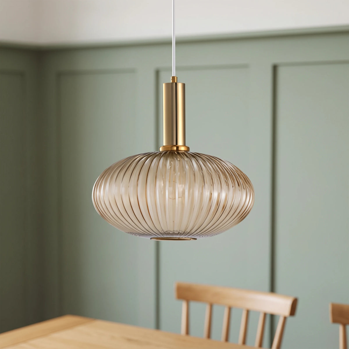 Kael wide champagne ribbed glass pendant light with a brass cap against a sage green panelled dining nook wall