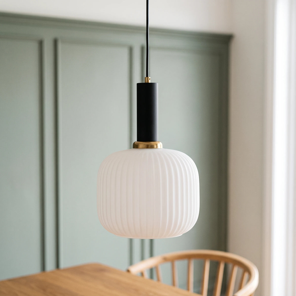 Kael white opal ribbed glass jar pendant light with a black cap against a sage green panelled dining nook wall