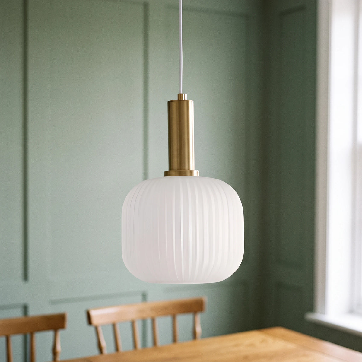 Kael white opal ribbed glass jar pendant light with a brass cap against a sage green panelled dining nook wall