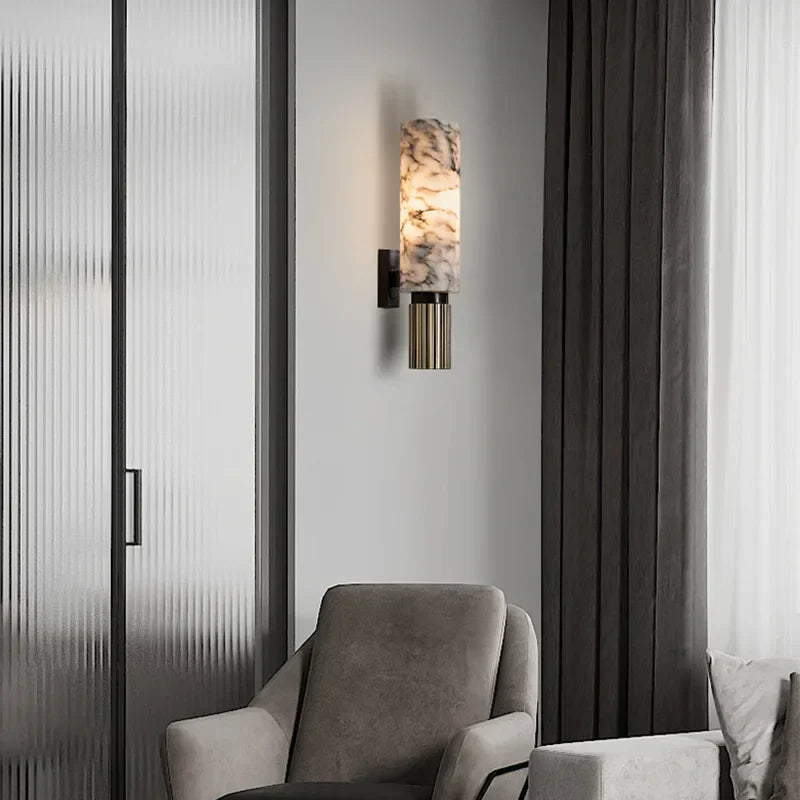 Elegant stone kopu wall lamp providing ambient accent lighting next to a modern grey armchair