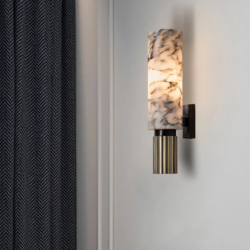 Genuine marble tube kopu wall sconce illuminating a dark panelled living room wall next to curtains