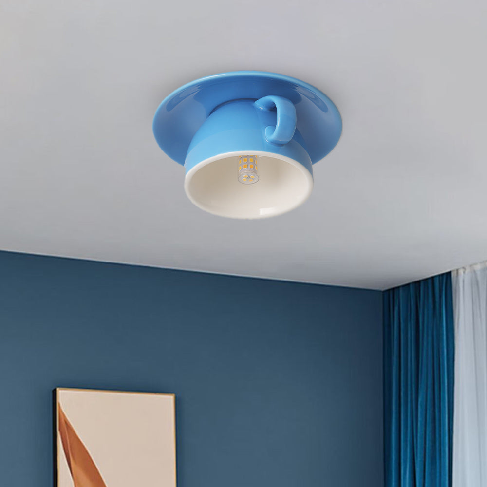 Blue novelty coffee cup flush mount kupce light illuminating a contemporary blue living room space