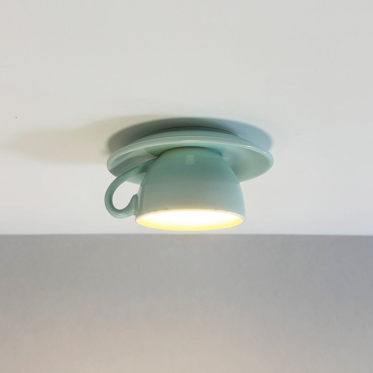 Light blue ceramic teacup kupce ceiling lamp providing soft ambient illumination