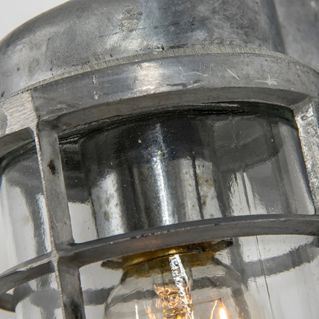 Close-up of the Laze silver bulkhead wall light cage, glass and bulb holder