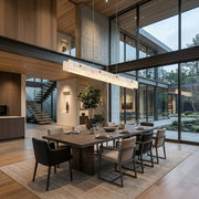Levon natural alabaster linear chandelier above a dining table in a modern open-plan room with a glazed wall