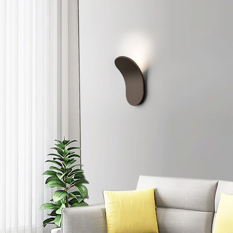 Modern lexi brown curved LED wall sconce providing indirect halo lighting in a contemporary living room