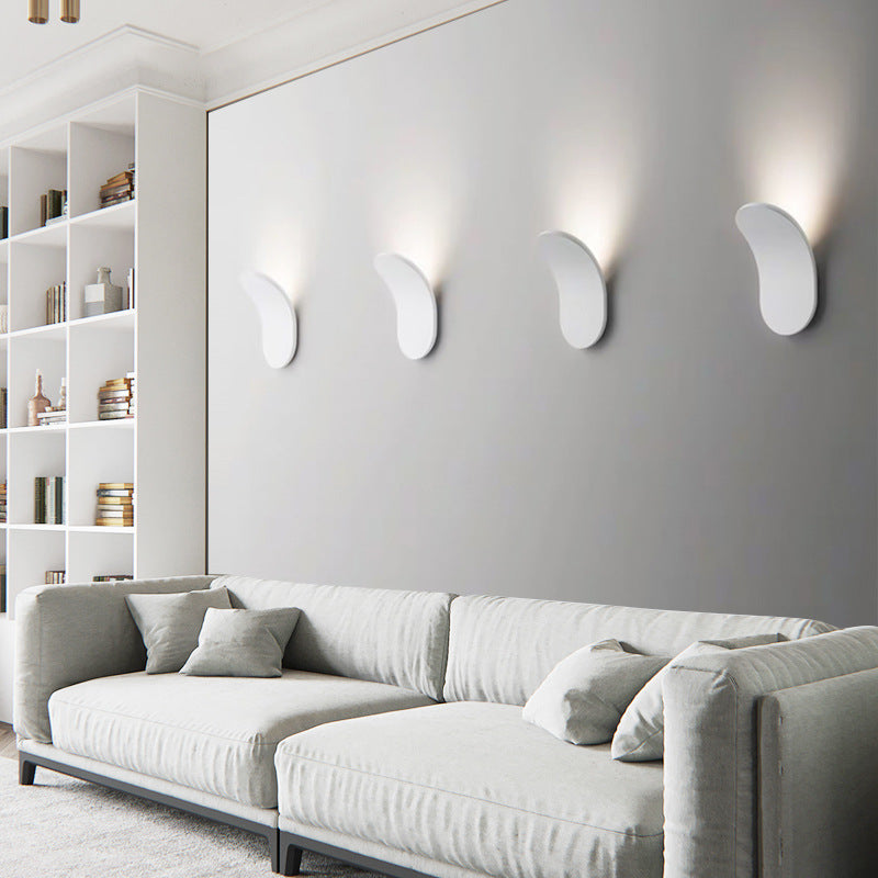Series of four white Nordic lexi wall lamps installed in a row above a modern living room sofa
