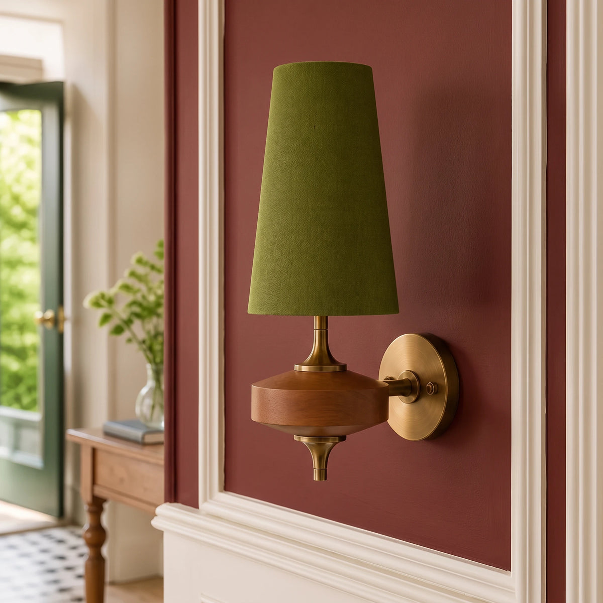 Lisk green fabric shade wall light on an oxblood panelled wall beside an open garden door