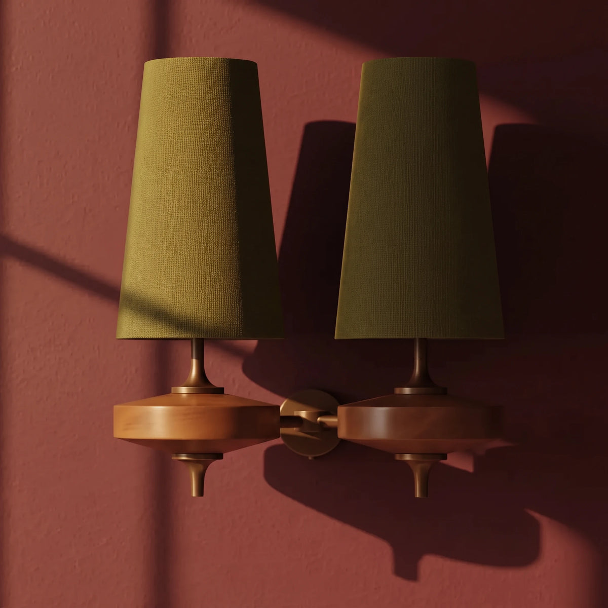 Close-up of the Lisk green 2-head fabric shade wall light on a plain oxblood wall