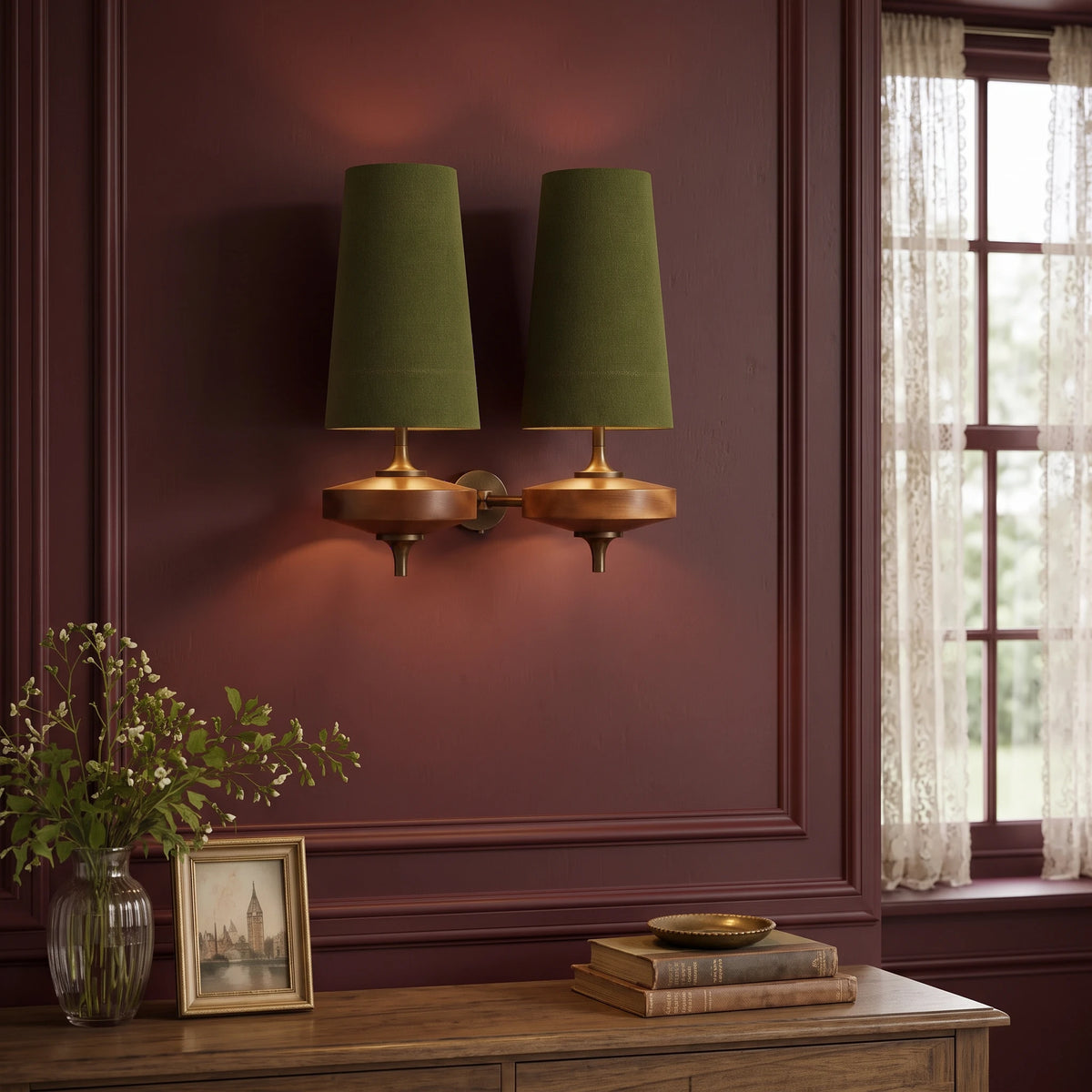Lisk green 2-head fabric shade wall light on an oxblood panelled wall above a console with a vase of foliage