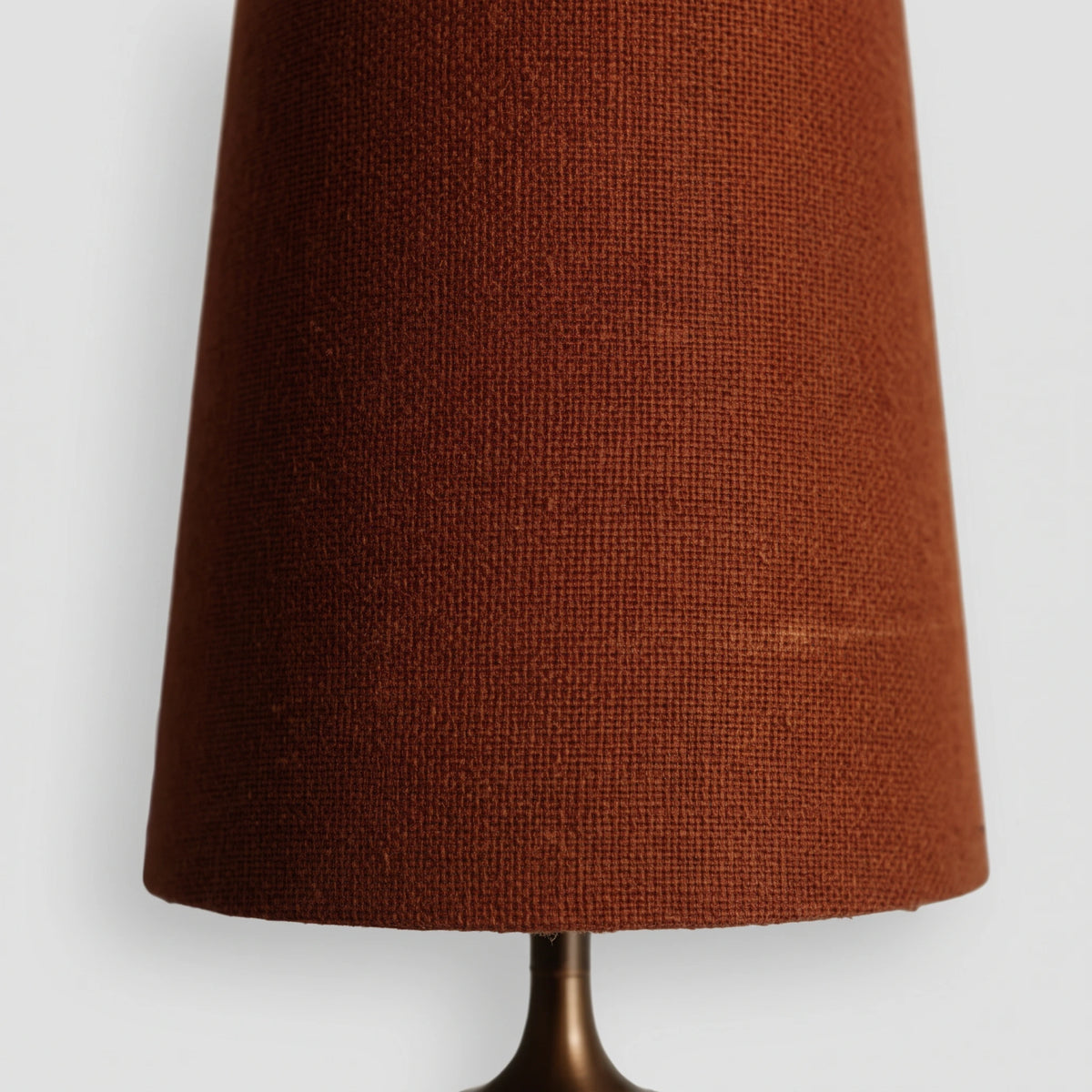 Close-up of the textured red fabric shade of the Lisk wall light