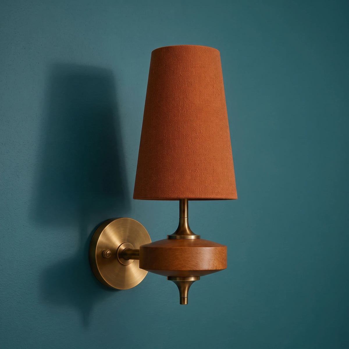 Close-up of the Lisk red fabric shade wall light on a plain deep teal wall