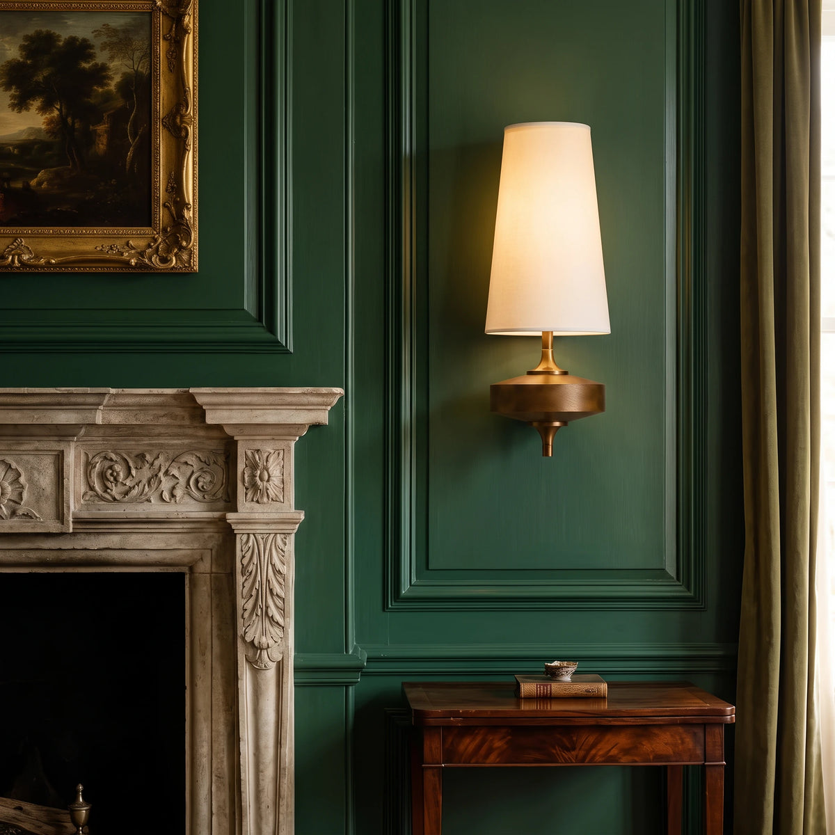 Lisk white fabric shade wall light on a green panelled wall beside a stone fireplace and a gilt-framed painting