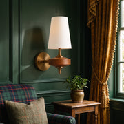 Lisk white fabric shade wall light on a racing green panelled wall beside a tartan armchair and gold tasselled curtain