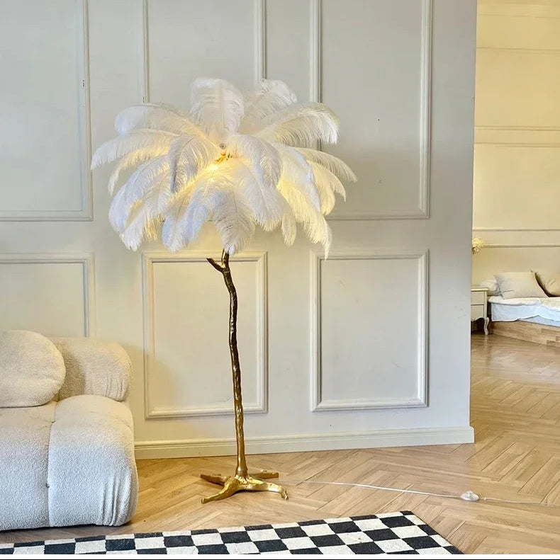 Lorne white ostrich feather floor lamp lit against a white panelled wall with a checkerboard rug and herringbone floor