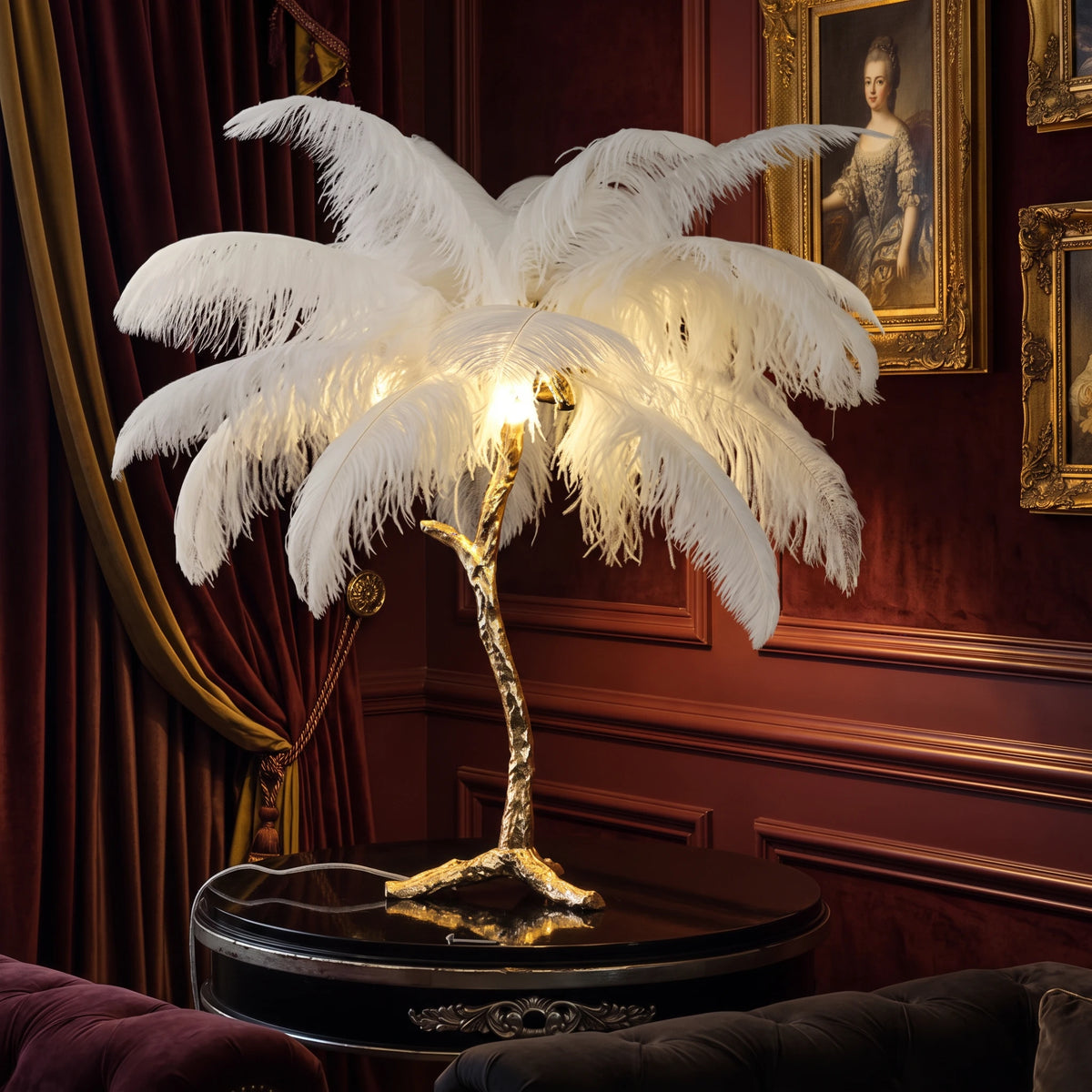 Lorne white ostrich feather lamp on a black side table against a burgundy velvet wall with gilt-framed portraits
