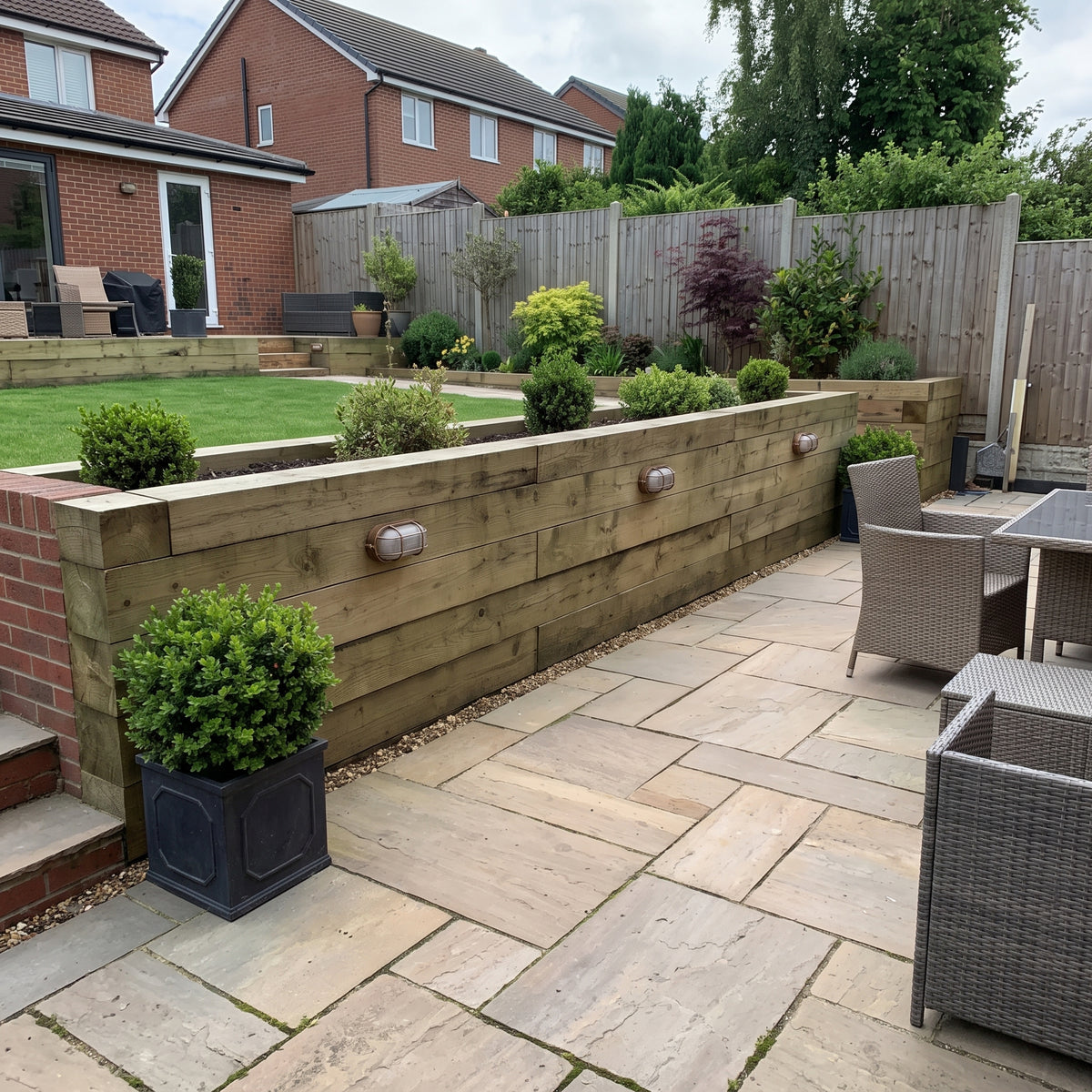 Lude bulkhead wall light on a garden timber retaining wall beside a patio