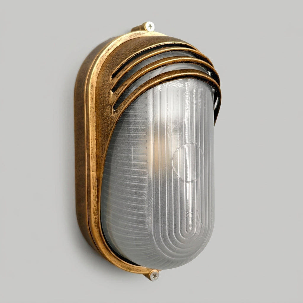 Lude louvred hood bulkhead wall light in aged bronze with ribbed glass, angled view on grey
