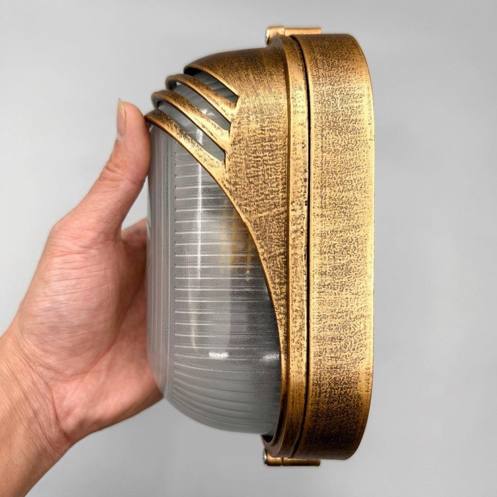Hand holding the Lude louvred hood bulkhead wall light to show its side profile and depth