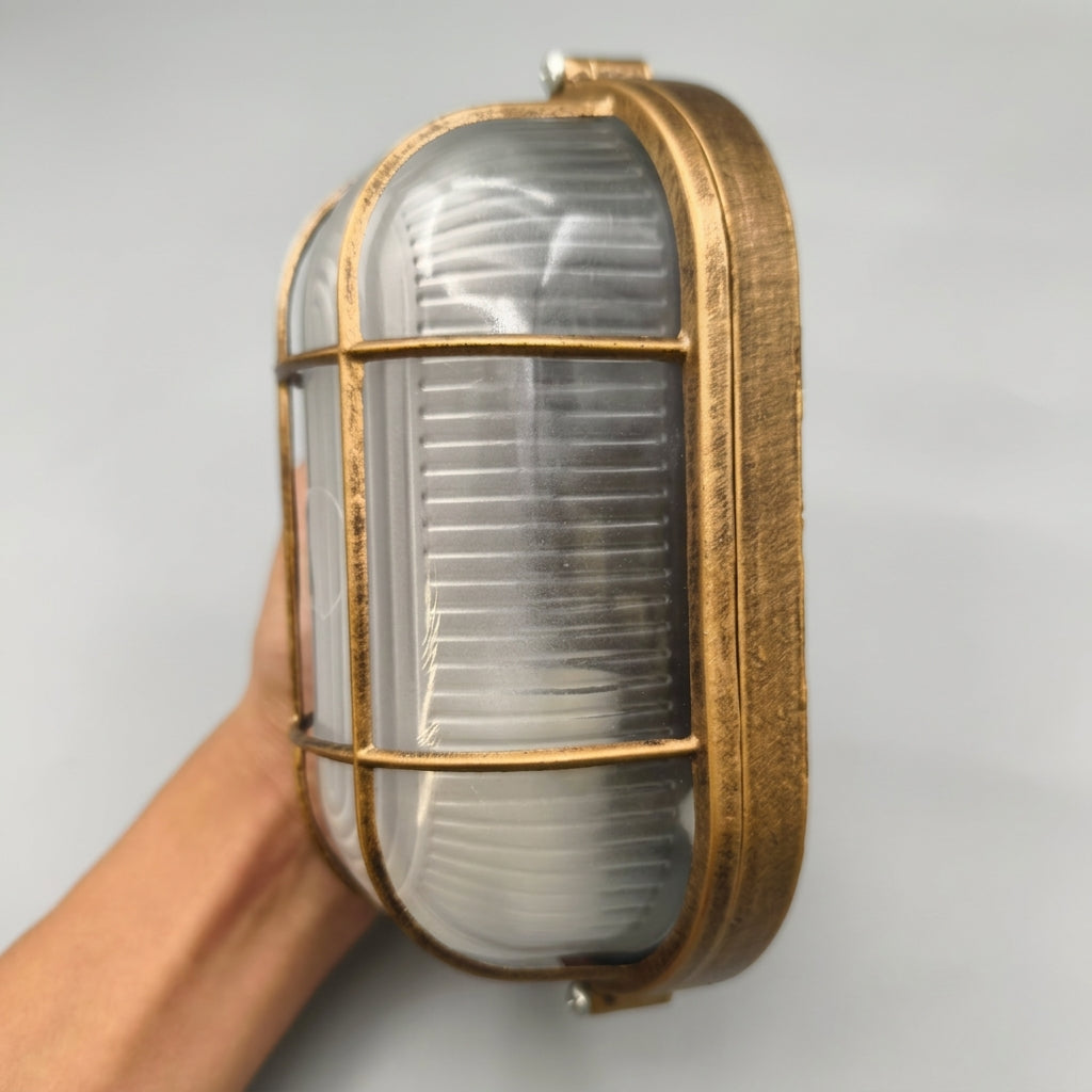 Hand holding the Lude cage guard bulkhead wall light to show its size and cage