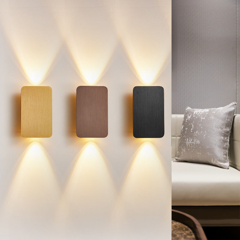 Three contemporary mazka rectangular LED wall sconces providing ambient light above a living room sofa