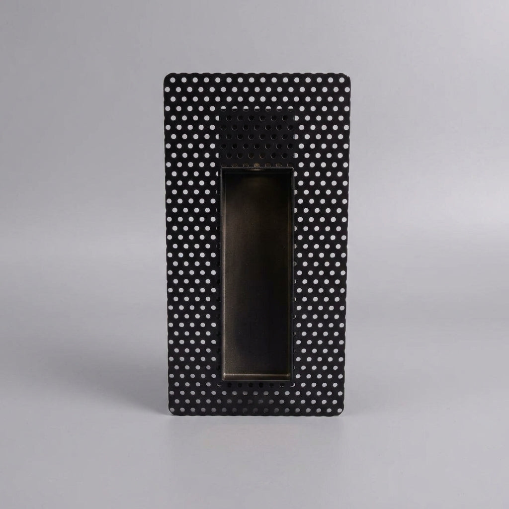 Melte black long strip perforated recessed LED wall light on a grey studio background