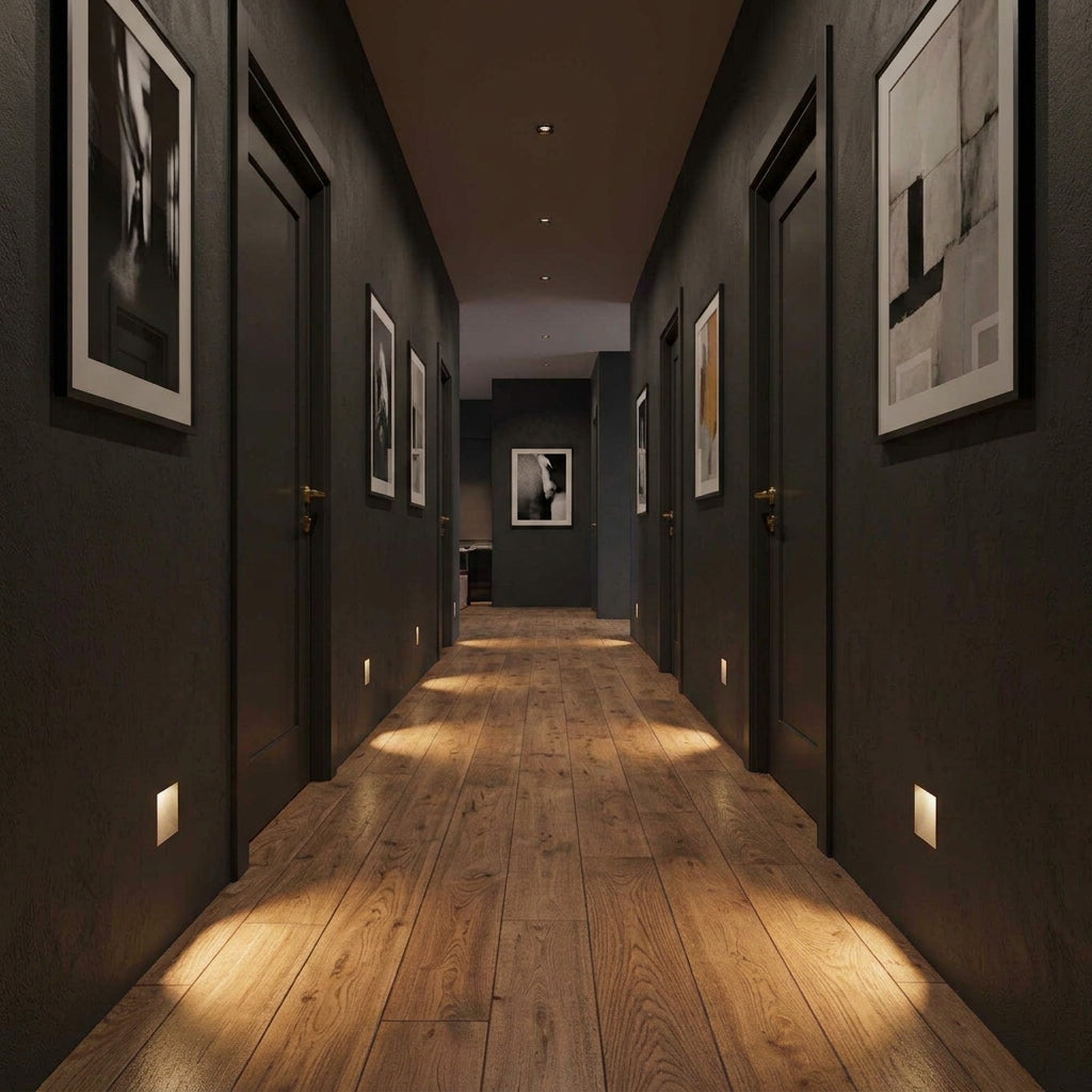 Melte recessed LED wall lights glowing along a dark corridor with a wooden floor