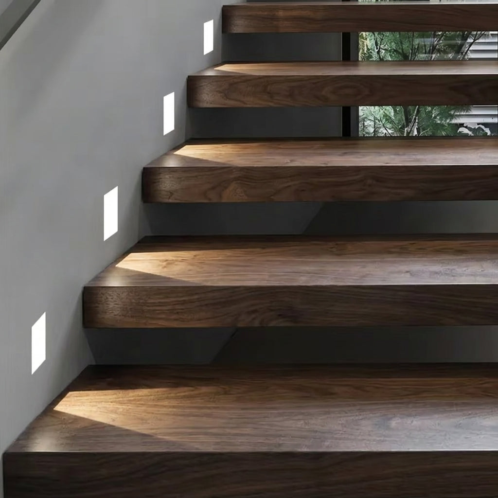 Melte recessed LED wall lights beside floating wooden stairs