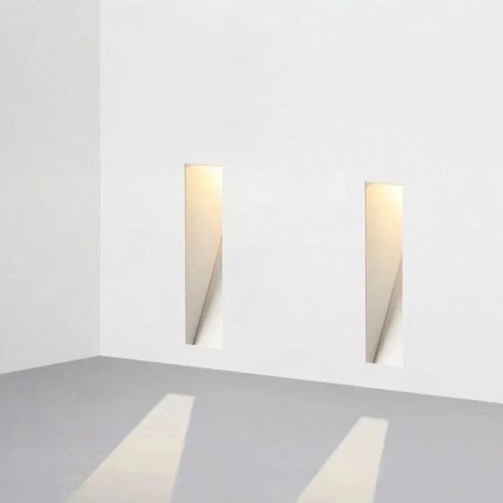 Pair of Melte white long strip recessed LED wall lights casting beams of light onto the floor